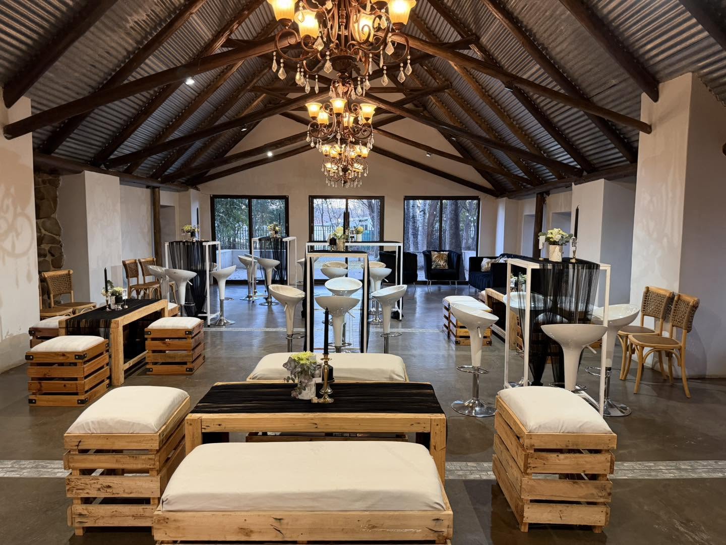 Kleinbosch's timber-beamed hall with chandeliers, lounge seating and cocktail tables